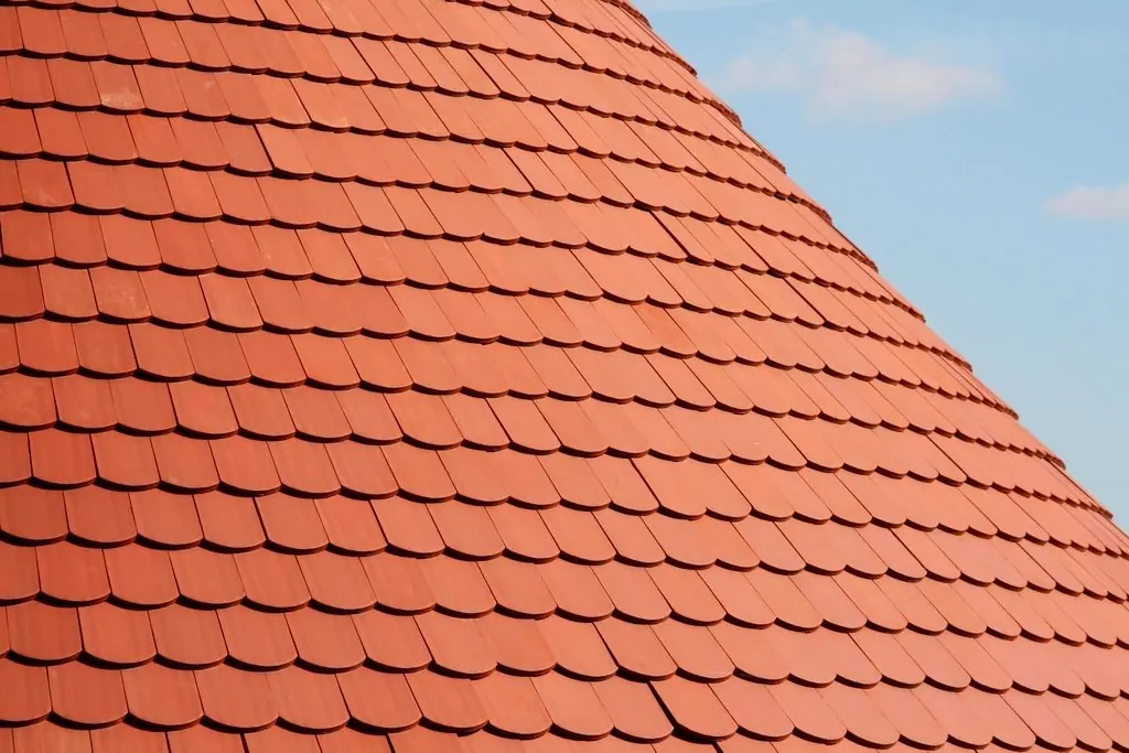 Strak gelegd rood pannendak tegen een blauwe lucht