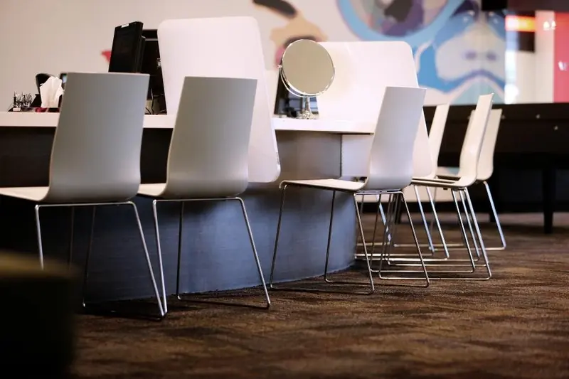 De wachthoek van Salon Camille met lichte stoelen op een rij